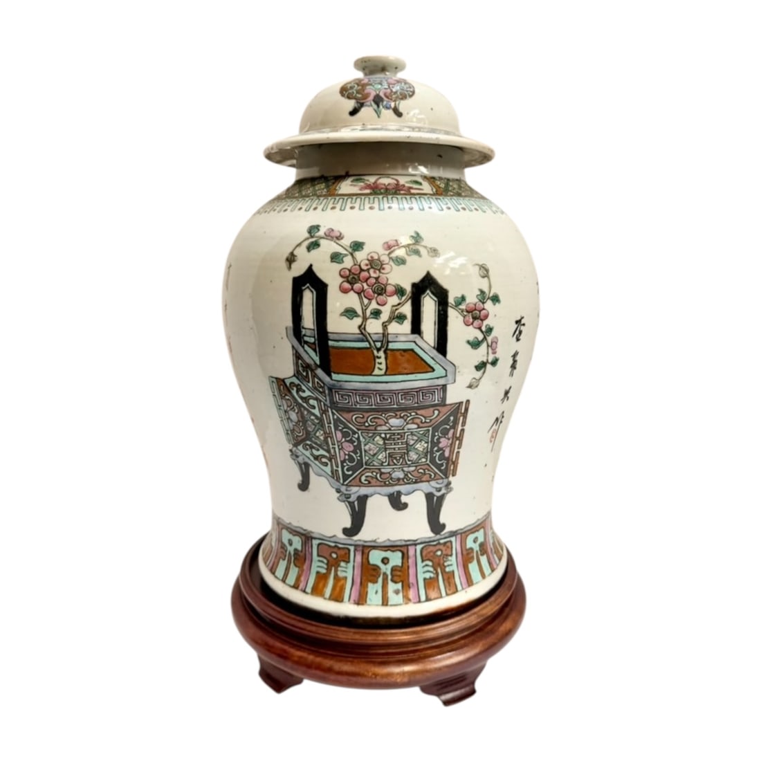 Chinese Famille Rose Baluster Jar with Cover & Wood Stand: Chinese porcelain baluster-form covered jar decorated in famille rose enamels with a scholar’s object / jardinière motif, flowering branches, geometric borders, lotus panels, auspicious symbols, an