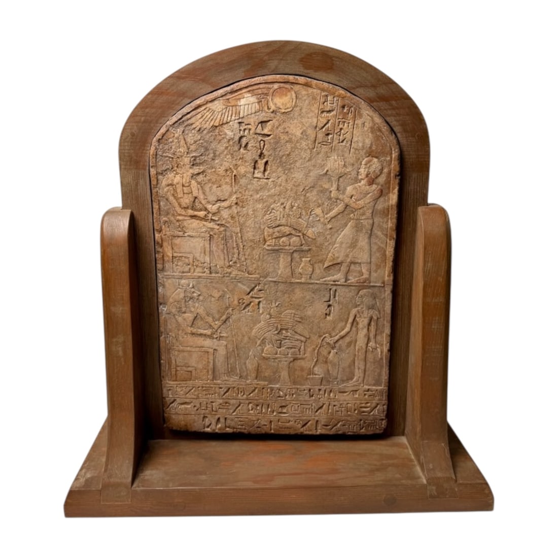 Egyptian Revival Carved Stone Relief Stele on Custom Wood Stand: Egyptian Revival carved stone relief depicting figures, hieroglyphs, and offering scenes, displayed in a custom wooden stand. The relief is modeled after an ancient Egyptian stele and makes an impress