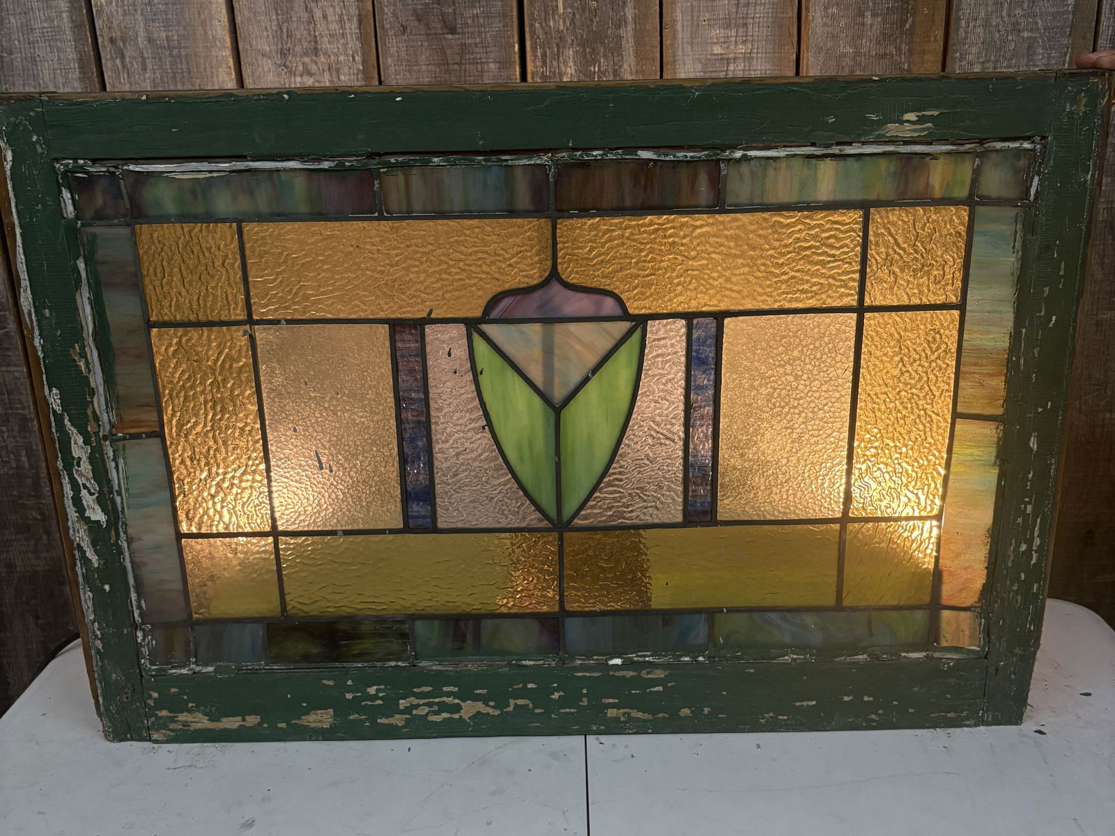 Late 19th or Early 20th-century Antique Stained Glass Window Panel with a Simple Centralized Crest: Late 19th or Early 20th-century Antique Stained Glass Window Panel with a Simple Centralized Crest and Foliate Decoration - 35.5"x24"