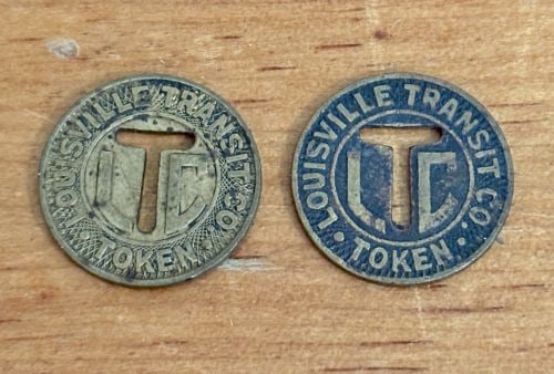 A Pair of Louisville Transit Co. Brass Fare Tokens, US .5": A pair of circular brass fare tokens issued by the Louisville Transit Co. of Kentucky. These specimens are die-struck with a central monogram cutout variety on an engine-turned lattice background. The