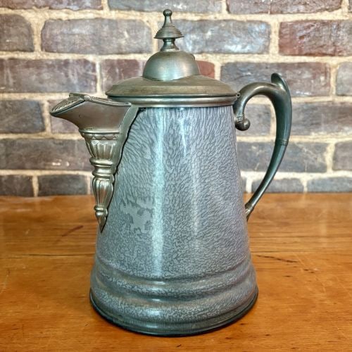 American Victorian Gray Mottled Graniteware Pitcher with Cast Metal Mounts 6"X9.5"X10.5": This antique Victorian pitcher features a tapered sheet metal body finished in mottled gray and white enamel, a style commonly known as graniteware or agateware. The vessel is fitted with ornate cast 
