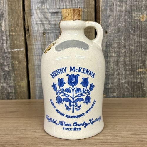 Henry McKenna Kentucky Whiskey Jug: A vintage decanter produced for the Henry McKenna brand of Kentucky whiskey. The vessel is constructed from glazed stoneware featuring cobalt blue transfer-print decoration. The front displays the bra