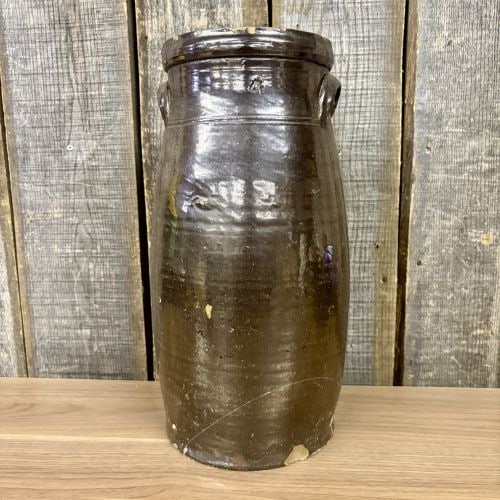 American 4 Gallon Stoneware Butter Churn with Albany Type Slip Glaze: An antique American stoneware butter churn of tall, cylindrical form. The vessel features a flared rim with an internal gallery designed to accommodate a lid and is flanked by two applied ear-shaped l