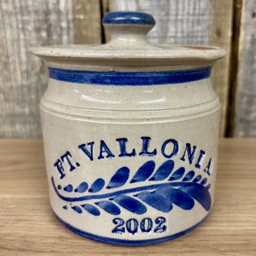 Hartley Pottery Fort Vallonia Days Commemorative Stoneware Lidded Jar, 2002: This contemporary salt-glazed stoneware lidded jar was produced by Hartley Pottery for the 2002 Fort Vallonia Days festival. The cylindrical crock features a slightly flared rim and a matching stonewa