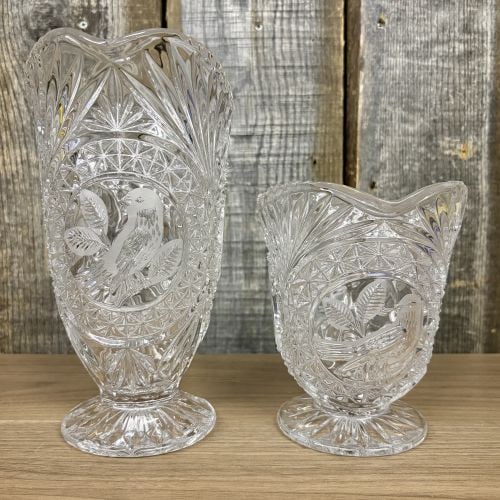 A Pair of Lead Cut Crystal Pitchers with Frosted Bird Medallions: This set consists of two pieces of lead cut crystal tableware featuring a matching pattern of frosted bird medallions and geometric cuts. The set includes a large footed water pitcher and a matching f