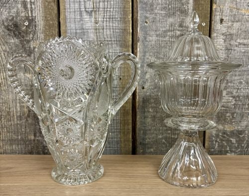 Two Pieces of Clear Decorative Glass Including an American Brilliant Period Style Cut Glass Loving: This lot consists of two pieces of clear decorative glass. The first item is a tall, two-handled vase in the American Brilliant Period (ABP) style, commonly referred to as a loving cup. The body featu