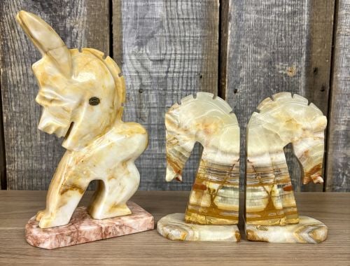 A Trio of Mexican Hand-Carved Onyx Stone Decorative Objects: A collection of three hand-carved onyx stone decorative items, consisting of a pair of stylized horse head bookends and a separate upright figurine of an anthropomorphic animal, likely a donkey or bra