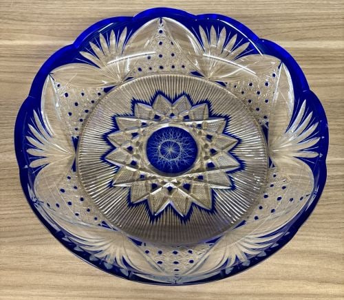 Bohemian Style Cobalt Blue Cased Cut to Clear Crystal Centerpiece Bowl: A large, shallow centerpiece bowl featuring a cobalt blue cased glass layer over a clear crystal base. The piece is decorated using intricate cut-to-clear techniques. The interior base displays a comp