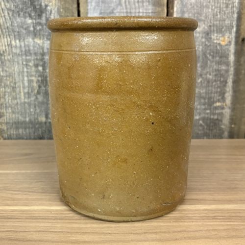 Nineteenth Century American Salt Glazed Stoneware Storage Jar: A cylindrical antique stoneware storage jar featuring a rounded rim and a single incised horizontal line at the shoulder. The exterior is finished in a light brown salt glaze with a characteristic ora