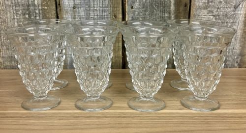 A Set of Eight Clear Pressed Glass Footed Iced Tea Tumblers in the Cube Pattern: A set of eight clear pressed glass footed iced tea tumblers in the Cube pattern, also commonly referred to as the Cubist pattern. These pieces are attributed to the Jeannette Glass Company based on th