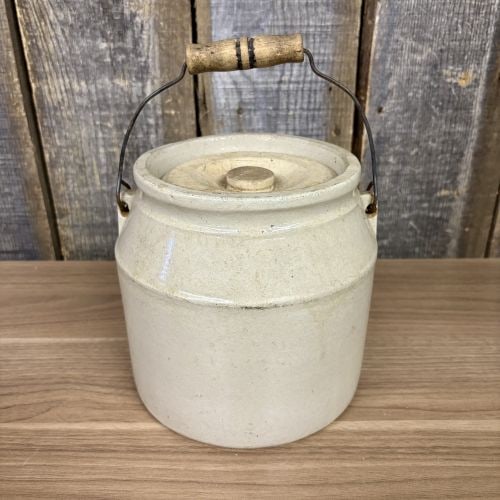 Antique Stoneware Utility Jar with Lid and Wire Bail Handle, Patent Dated 1896: A cylindrical stoneware utility jar finished in an off-white Bristol-style glaze. The jar features sloped shoulders, a wide rim, and a matching recessed ceramic lid with a central knob. It is equipped