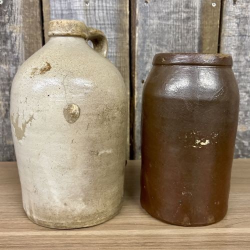Two Antique American Salt-Glazed and Albany-Slip Glazed Stoneware Utility Vessels: This lot consists of two antique American stoneware utility vessels, likely dating from the 19th to early 20th century. The first vessel is a single-handled rounded shoulder jug featuring an applied s
