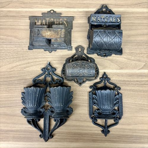 A Group of Five Victorian Cast Iron Wall Mounted Match Holders and Decorative Wall Pockets: This group of five Victorian era items consists of cast iron wall mounted match holders and decorative wall pockets. One match holder features an openwork backplate with the word MATCHES above a lidde