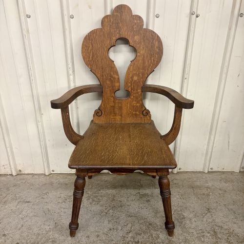 Quartersawn Oak Armchair in the Dutch Colonial Revival Style: This single armchair is constructed from solid quartersawn oak, also known as tiger oak, which is distinguished by prominent medullary ray flecks throughout the wood grain. The piece reflects an early