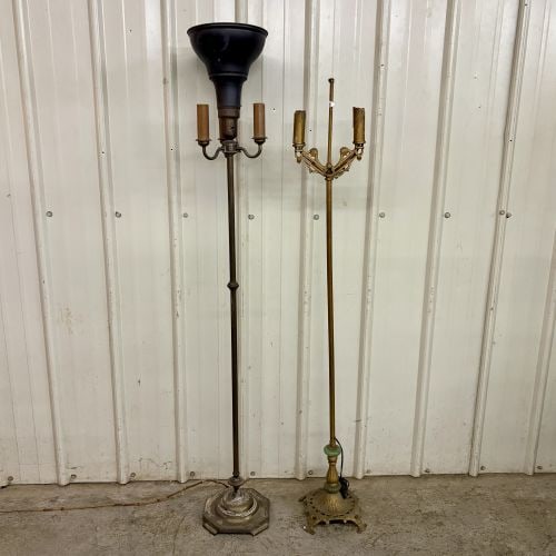 Two Vintage Cast Metal Floor Lamps in Art Deco and Candelabra Styles: This lot consists of two vintage cast metal floor lamps of different decorative styles. The first is an Art Deco style torchere lamp featuring a black metal trumpet-shaped reflector shade at the top. 