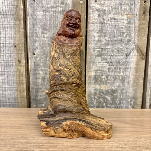 Hand-Carved Cedar Wood Root Happy Buddha Sculpture: This contemporary hand-carved decorative sculpture depicts the Laughing Buddha, also known as Budai or Hotei. The figure is sculpted from a single section of a tree trunk or root, possibly cedar, util