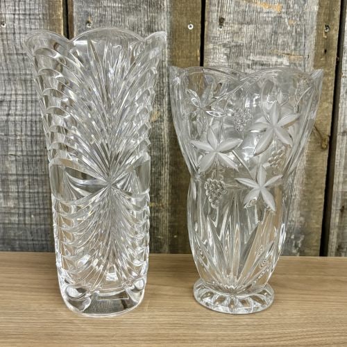A Pair of Cut and Frosted Crystal Vases: This lot features two clear lead crystal vases of varying styles and dimensions. The first is a tall, tapered vase characterized by a deeply cut pinwheel or feathered sunburst pattern that radiates ac