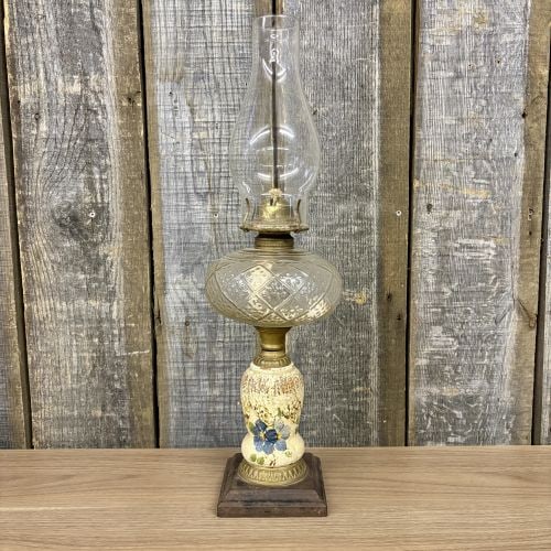 Plume and Atwood Victorian Hand Painted Ceramic and Glass Oil Lamp: This antique kerosene oil lamp is a composite piece featuring components of glass, brass, ceramic, and wood. The burner assembly is made of brass and features a wick adjustment knob embossed with Sunl