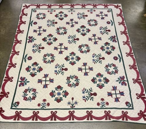 Large Hand-Appliqued and Hand-Quilted Cotton Bed Quilt with Floral and Bow Motifs: This large floral applique bed quilt with a ribbons and bows border features extensive hand-appliqued and hand-quilted construction, dating from the late 20th century. The center field displays variou