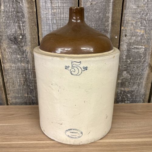 Western Stoneware Company Five Gallon Two Tone Beehive Jug: A large five gallon stoneware shoulder jug manufactured by the Western Stoneware Company of Monmouth, Illinois. The vessel features a beehive form with a two-tone glaze, consisting of a cream-colored 