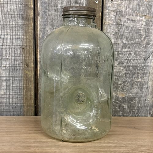 Vintage Camp Minnow Trap Glass Bait Jar Checotah Oklahoma: This vintage Camp Minnow Trap is a molded glass bait trap used by fishermen in the mid-20th century. The heavy glass body is formed in a rounded rectangular shape and features a distinctive side-entry