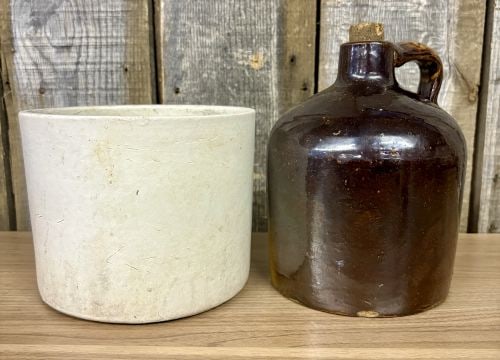 Two Pieces of American Utilitarian Stoneware Including a Two-Tone Jug and a Cylindrical Crock: This lot comprises two pieces of American utility stoneware, typical of late 19th to early 20th-century production. The first item is a wheel-thrown cylindrical stoneware crock or planter finished in 
