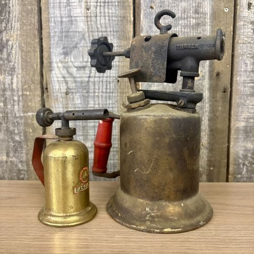 Two Vintage American Brass Gasoline Blow Torches, Turner and Lenk: This lot features two vintage gasoline blow torches of American manufacture, dating to the mid-20th century. The larger unit is a Turner Brass Works model 206AK, produced in Sycamore, Illinois. It fea