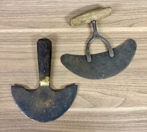 Two Antique Hand Tools: A Rocking Herb Chopper and a Leatherworker's Head Knife: This lot features two antique utility hand tools, likely dating from the late 19th to early 20th century. The first item is a single-blade rocking herb chopper, also known as a mezzaluna, used for min