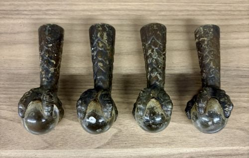 A Set of Antique Cast Iron and Glass Ball Claw Ferrule Feet: This set of four matching antique furniture ferrule feet is designed in the classic claw and ball style. Each piece is constructed from cast iron with a tapered socket and features a bird or dragon cl