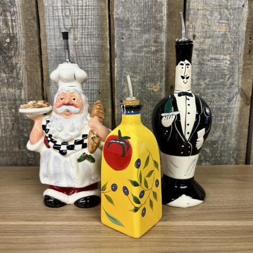 A Trio of Contemporary Ceramic Figural and Decorated Kitchen Cruets including Dansk and Giftco: A trio of contemporary earthenware kitchen cruets with various figural and botanical themes. The first vessel is a figural dispenser depicting a Santa Claus character dressed as a chef, wearing a tall
