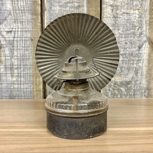 Antique Metal and Pressed Glass Bracket Lamp with Fluted Reflector: This antique kerosene bracket lamp consists of a clear pressed glass fuel font seated within a dark-finished sheet metal base. The glass reservoir features a fluted or gadrooned pattern around the sho