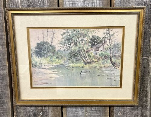 Paul Sawyier, River Scene with Cabin, Framed Print: This framed landscape print, after an original work by Kentucky artist Paul Sawyier (1865–1917), depicts a tranquil river scene with a rustic cabin nestled among trees on the bank. Executed in an im