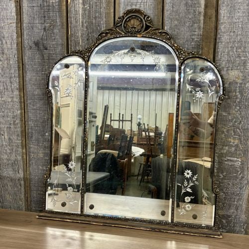 Venetian Style Etched Glass Triptych Mantel Mirror: This three-panel triptych wall mirror is designed in the Venetian style and dates to the early to mid-20th century. The mirror features a molded frame with a metallic bronzed and gilded finish, includ