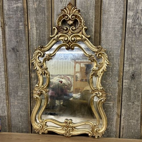 Rococo Revival Style Gilded Molded Wall Mirror: A large wall mirror in the Rococo Revival style, likely produced in the mid-to-late 20th century. The frame is constructed from a molded composite material with an antique-gold gilded finish. The orna
