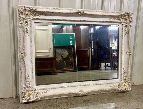 Large Rococo Revival Style Gilt and Off-White Beveled Wall Mirror: A large rectangular wall mirror featuring an ornate frame in the Rococo Revival style. The frame is constructed from a wood or composite material with elaborate molded high-relief decoration, includin
