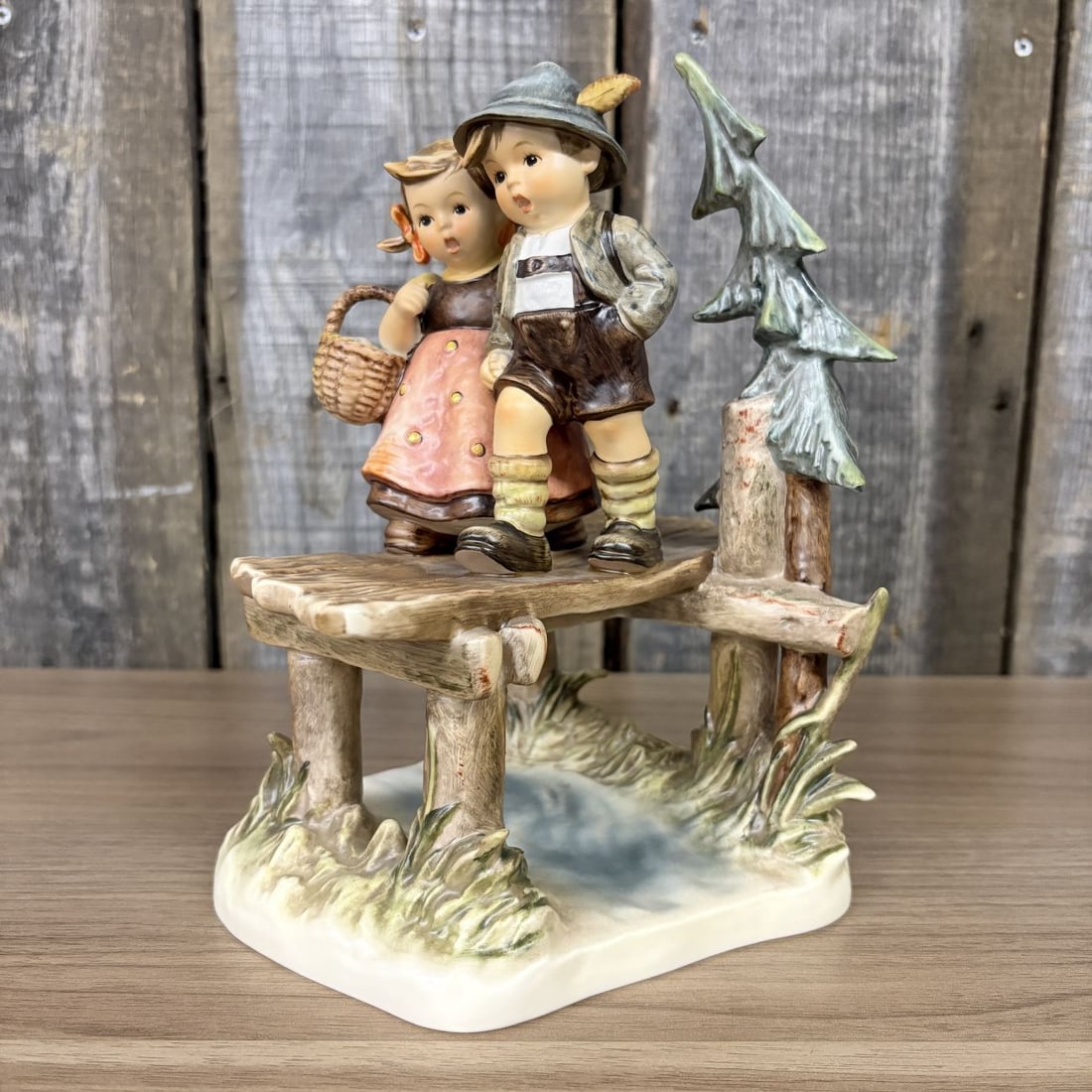 Goebel Hummel On Our Way Century Collection Figurine Model 472: A Goebel M.I. Hummel hand-painted porcelain figurine titled On Our Way (German: Bald sind wir dr¸ben), identifying as the seventh issue in the Century Collection. The piece depicts a young boy and gi