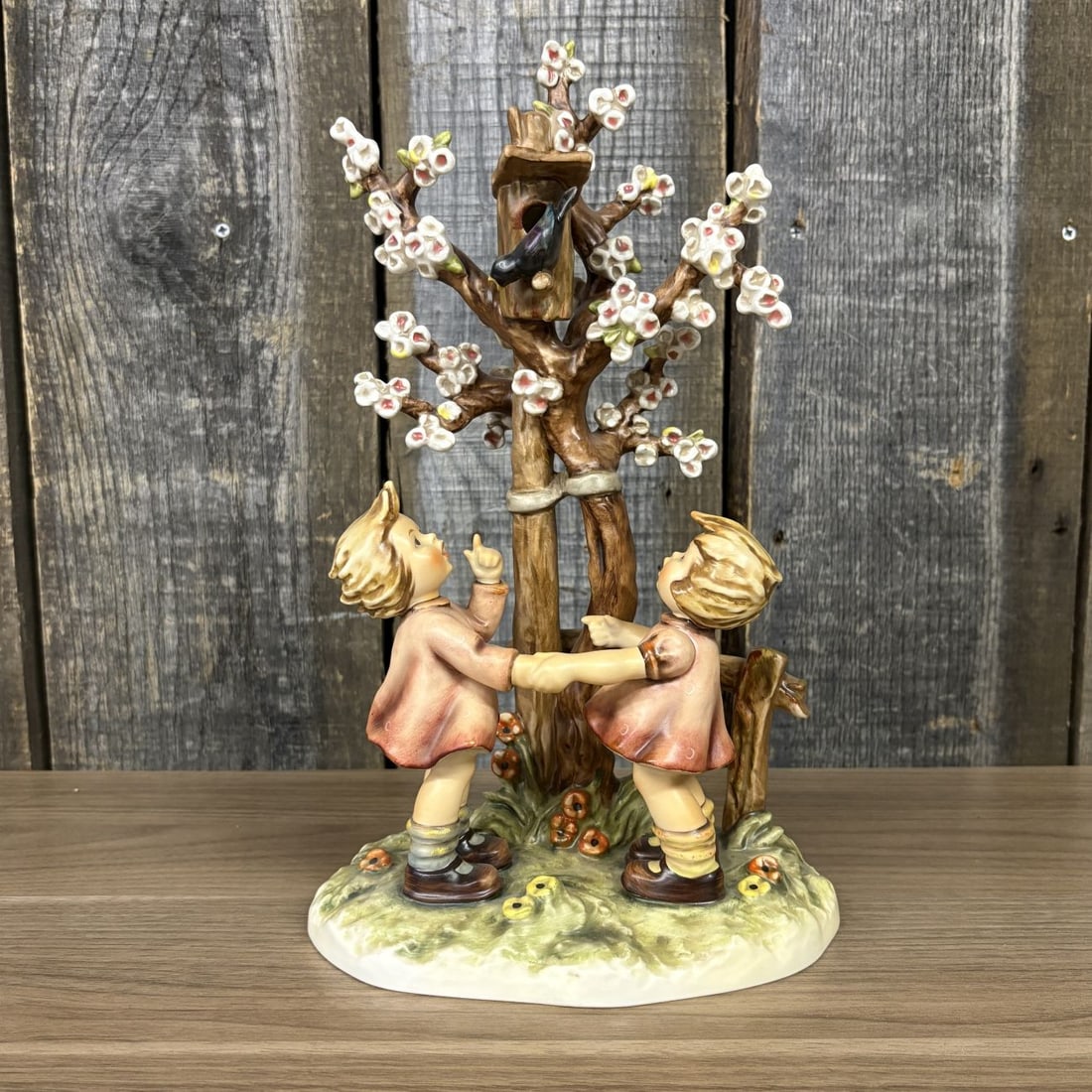 Goebel M.I. Hummel Century Collection Welcome Spring Porcelain Figurine Hum 635: This large-scale Goebel M.I. Hummel porcelain figurine is titled Welcome Spring (German title: Fruehlingstanz), model number 635. The piece depicts two young girls in reddish-brown dresses holding han