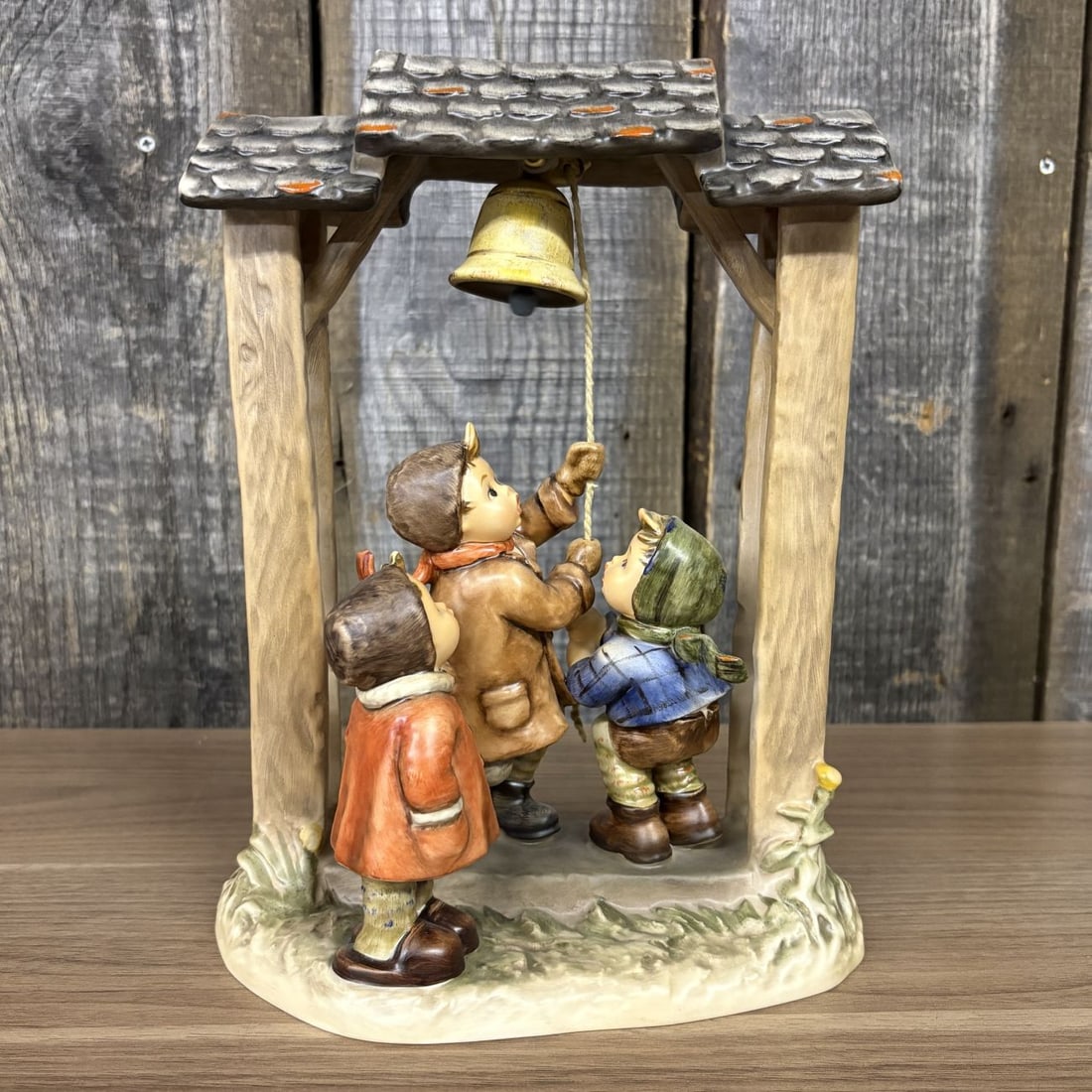 Goebel M.I. Hummel Century Collection Let's Tell The World Porcelain Figurine 487: This Goebel M.I. Hummel hand-painted porcelain figurine is titled Let's Tell The World, also known by the German title Sturmlaeuten. Identified as model number 487, it represents the fifth issue withi