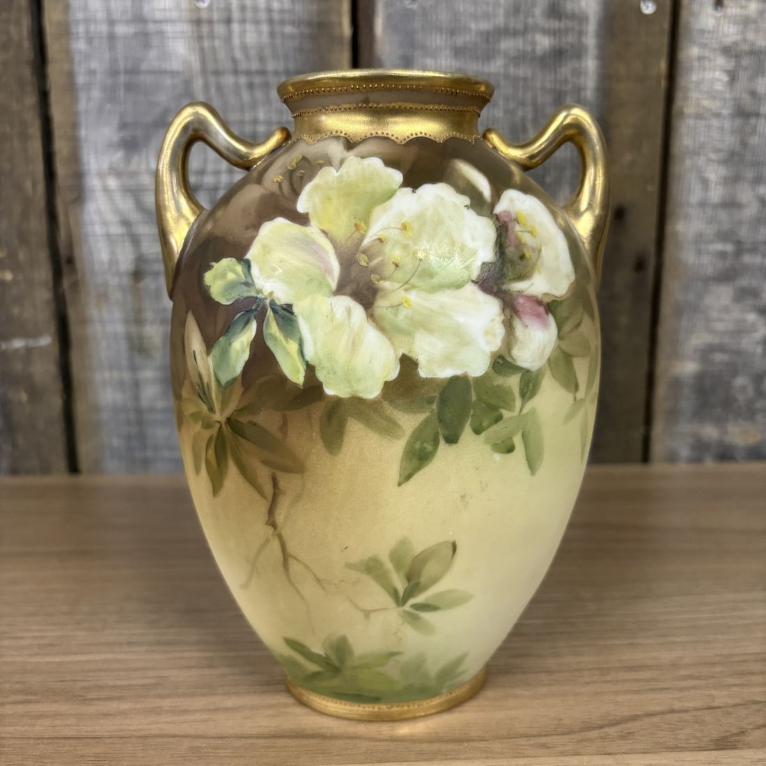 Morimura Brothers Nippon Hand Painted Floral Porcelain Two Handled Vase: A Morimura Brothers Nippon hand-painted porcelain vase featuring an ovoid body and two scrolled handles. The exterior is decorated with a shaded matte ground transitioning from dark brown at the shoul