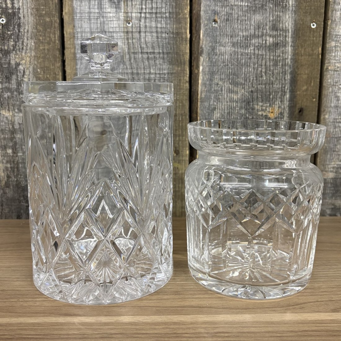Two Cut Crystal Vessels Including a Waterford Lismore Biscuit Barrel: This lot features two pieces of colorless lead crystal. The first is a Waterford biscuit barrel in the Lismore pattern, characterized by a cylindrical form with a deep-cut pattern of diamonds at the b
