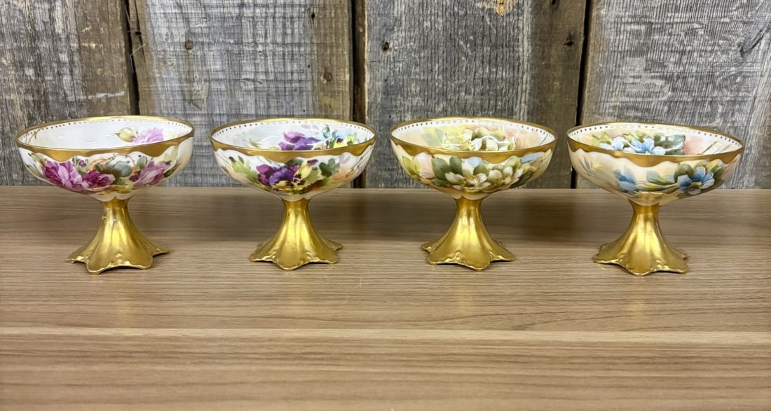 A Set of Four Haviland Limoges Hand Painted Porcelain Footed Dishes Signed M. Blanche Lenzi: This set of four fine porcelain pedestal bowls or compotes was manufactured by Haviland and Co. in Limoges, France. Each piece features a shallow, scalloped bowl supported by a tapered stem and a flar
