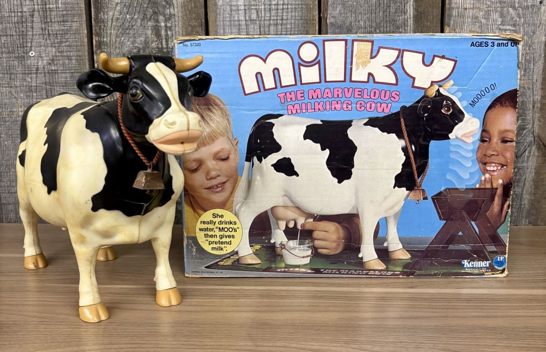 1977 Kenner Milky The Marvelous Milking Cow with Original Box: A 1977 mechanical action toy cow manufactured by Kenner (General Mills Fun Group, Inc.), titled Milky The Marvelous Milking Cow. The toy is constructed of a molded plastic body with black and white pa