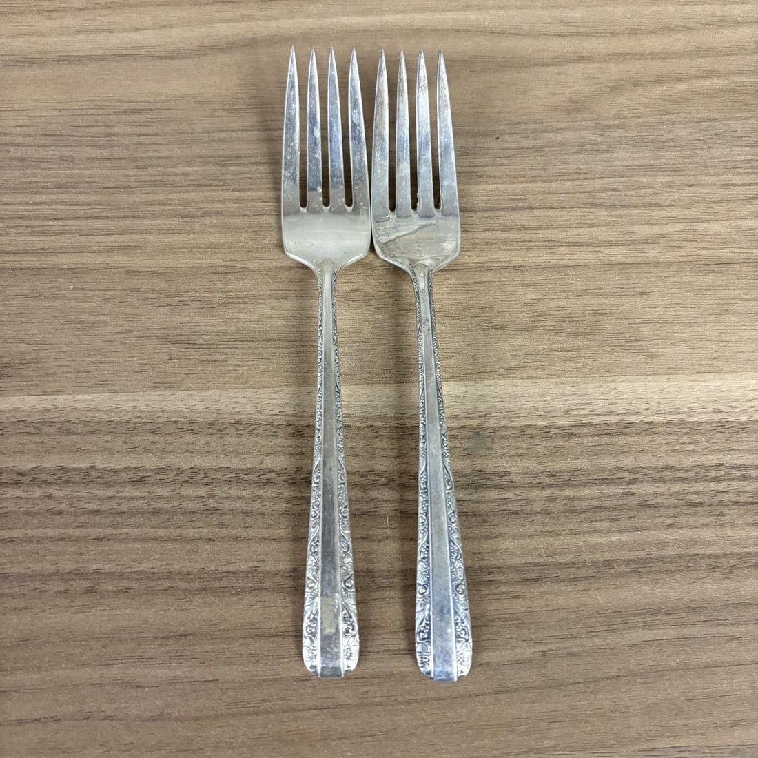 A Pair of Towle Sterling Silver Salad Forks in the Candlelight Pattern: This pair of salad forks is produced in the Candlelight pattern by Towle Silversmiths. Each piece is constructed from sterling silver and features a traditional design of floral and scrollwork borders
