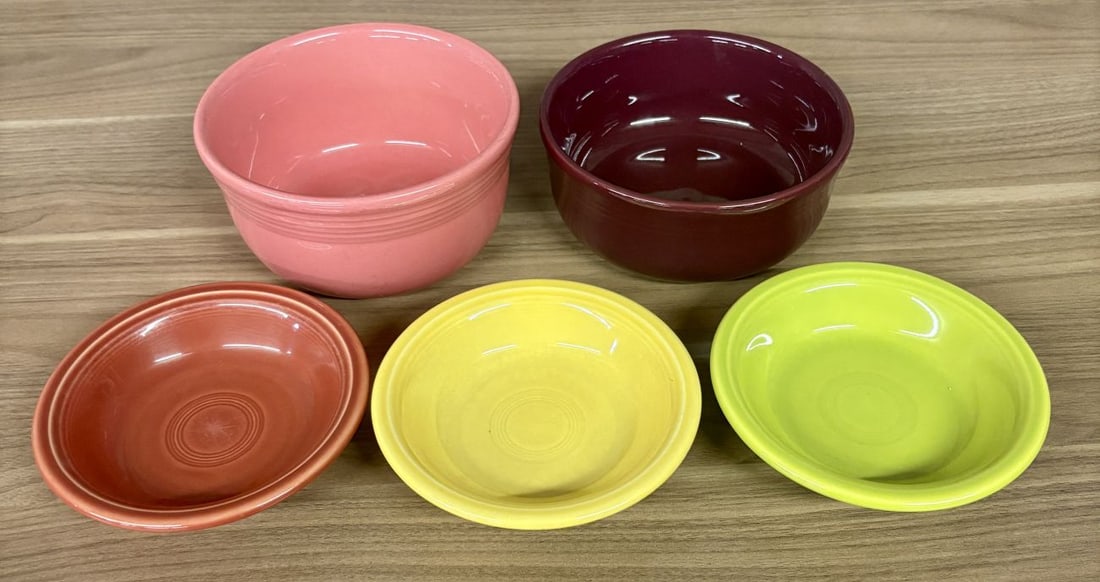 A Set of Five Homer Laughlin Fiestaware Ceramic Bowls and Dishes in Various Colors: This set of ceramic dinnerware is produced by the Homer Laughlin China Company in the Fiesta pattern. The collection consists of two deep Gusto bowls and three shallow fruit or dessert bowls, all cons