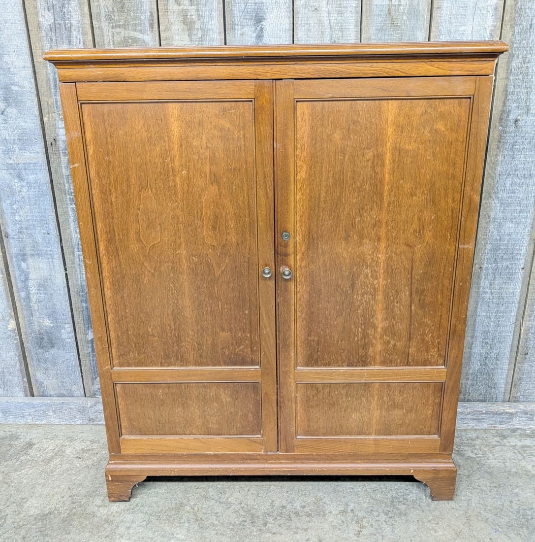 Mid-Century Transitional Walnut Veneer Two-Door Storage Cabinet: This mid-20th-century storage cabinet is of one-piece construction, featuring a transitional style suitable for an office or library environment. The exterior is finished in walnut veneer over a secon