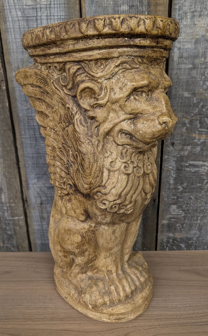 Winged Lion Saint Mark Cast Stone Column Pedestal: This cast stone pedestal features the Winged Lion of Saint Mark in a Neoclassical monopodium style. The stand is finished with an antiqued buff-colored patina and serves as a decorative support or pli