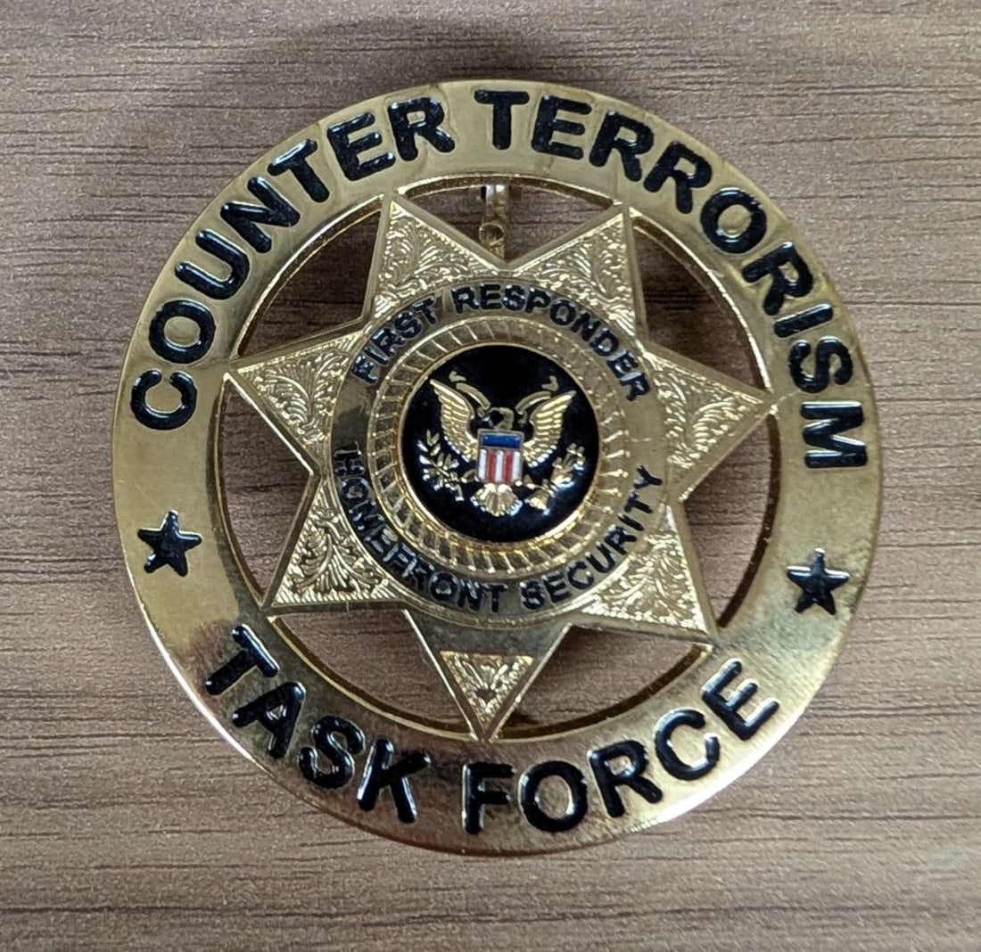 Counter Terrorism Homefront Security Task Force Commemorative Badge: This is a commemorative or novelty pin-back badge, identified as a Counter Terrorism Homefront Security pattern. The badge is constructed from a gold-toned base metal featuring a multi-layered design.