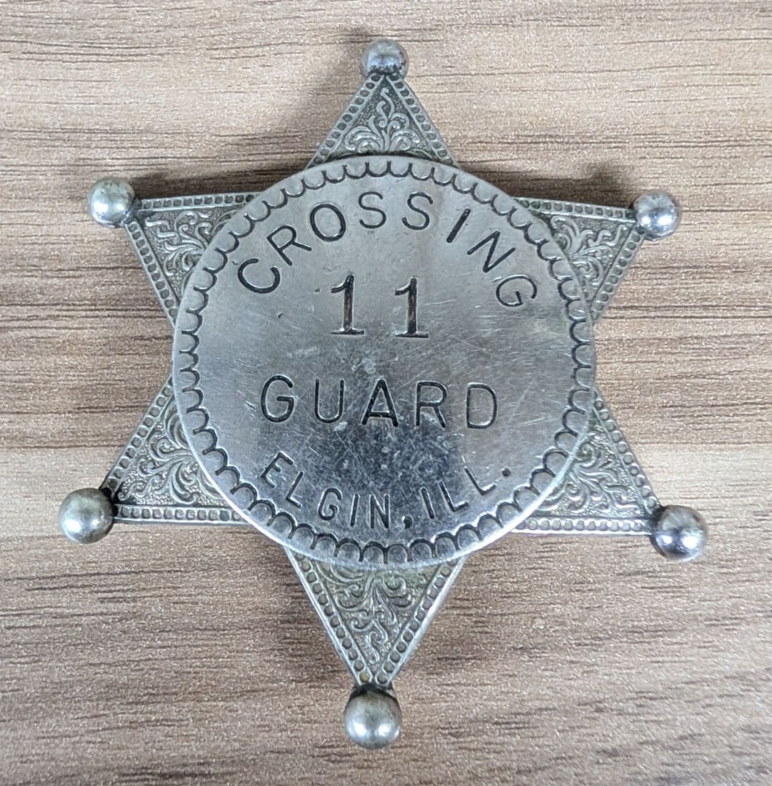 Vintage W.S. Darley and Co. Elgin Illinois Crossing Guard Badge Number 11: This civil service badge was manufactured by W.S. Darley and Company for a crossing guard in Elgin, Illinois. The badge is constructed of a silver-toned metal, likely nickel-plated brass, in the form 