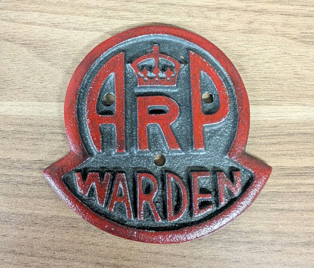 WWII British Air Raid Precautions ARP Warden Cast Iron Post Door Plaque: This is a cast iron Air Raid Precautions (ARP) Warden post door plaque, a piece of British Civil Defense memorabilia. The plaque is cast in heavy metal with a shield-shaped profile and a flared base. 