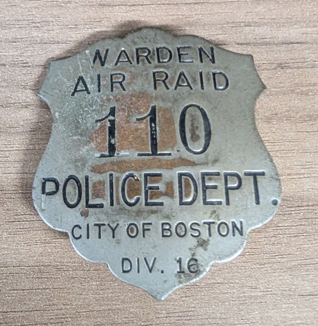 WWII City of Boston Police Department Division 16 Air Raid Warden Badge No. 110: This is a stamped metal shield-style badge issued to a civilian Air Raid Warden by the Boston Police Department during World War II. The badge is constructed from a silver-toned base metal with a scal